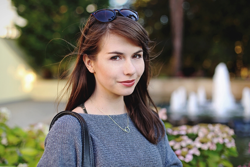 Szary sweter i naszyjnik z obrączkami