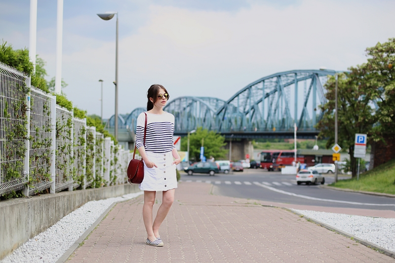 Trapezowa spódniczka, paski i skórzana torebka