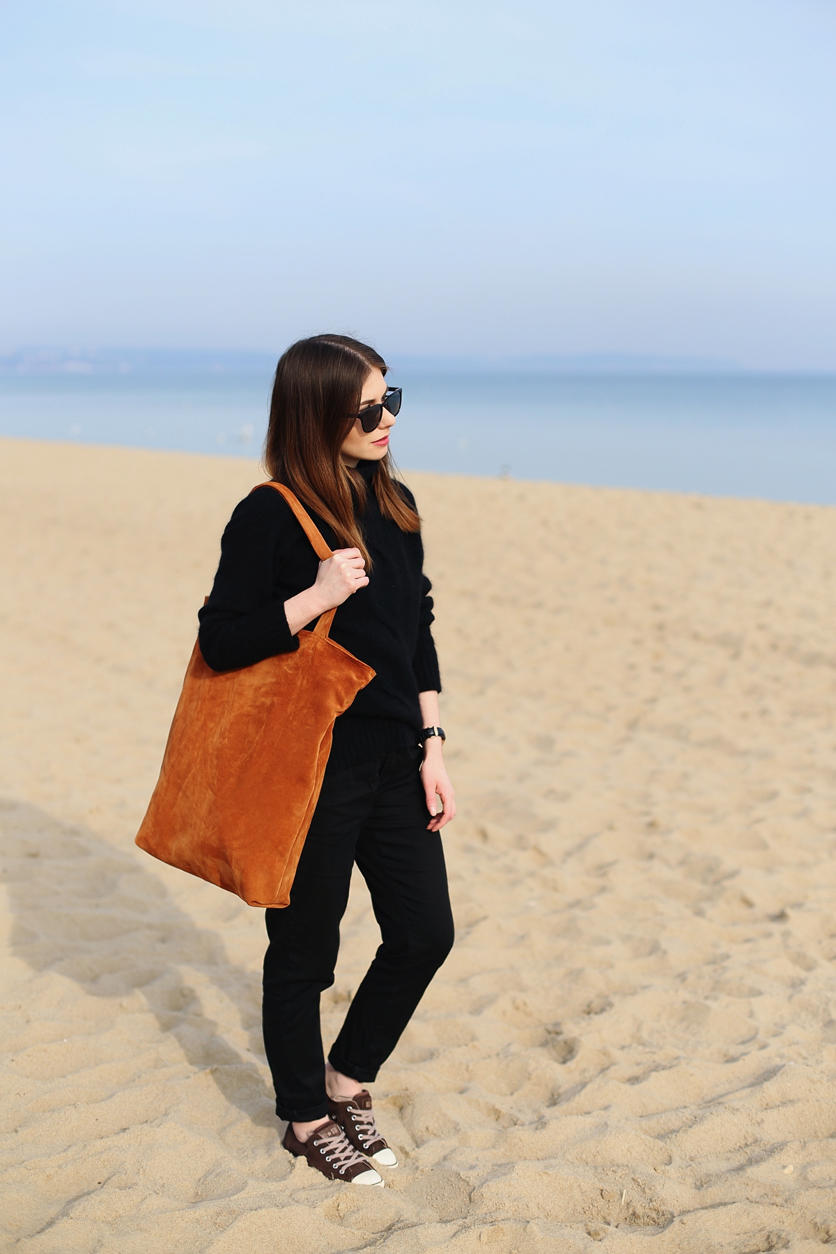 Czarna minimalistyczna stylizacja i ruda skórzana torba