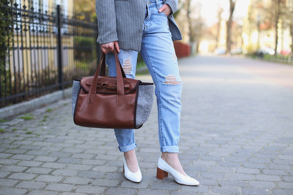 Spodnie boyfriend z dziurami, białe buty i torebka polskiej marki ze skóry i filcu