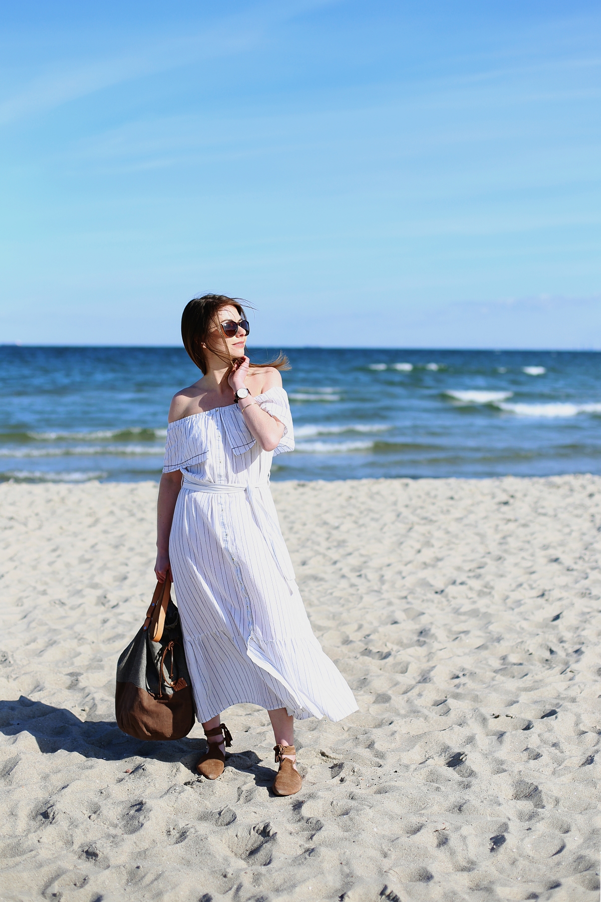 Biała sukienka z odkrytymi ramionami - sesja modowa na plaży