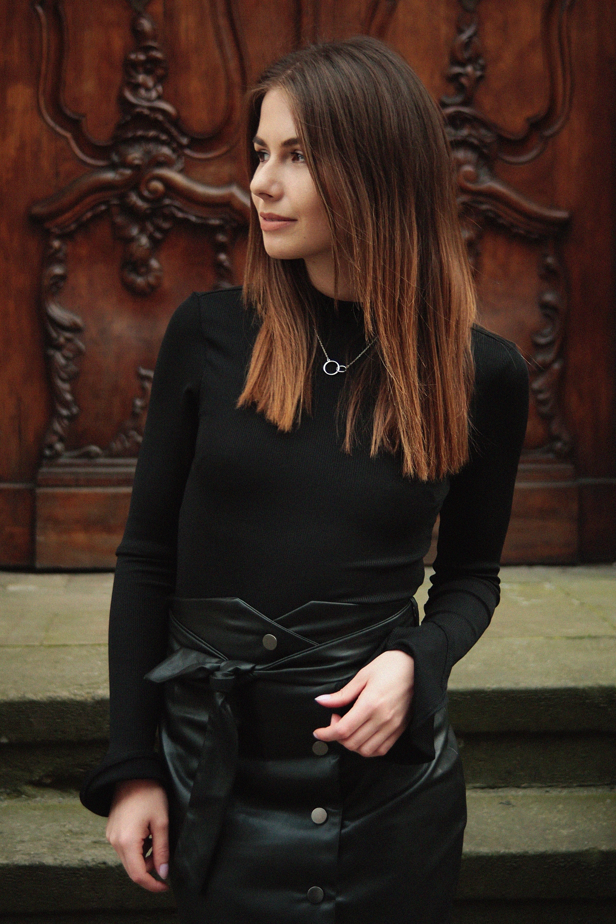 Kobieca stylizacja ze skórzaną spódnicą i czerwonymi szpilkami