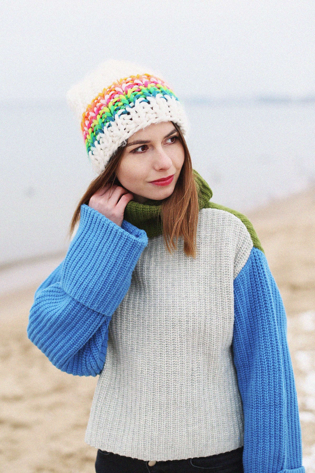 Kolorowy outfit zimowy: szeroki sweter z golfem & biała czapka o dużym splocie