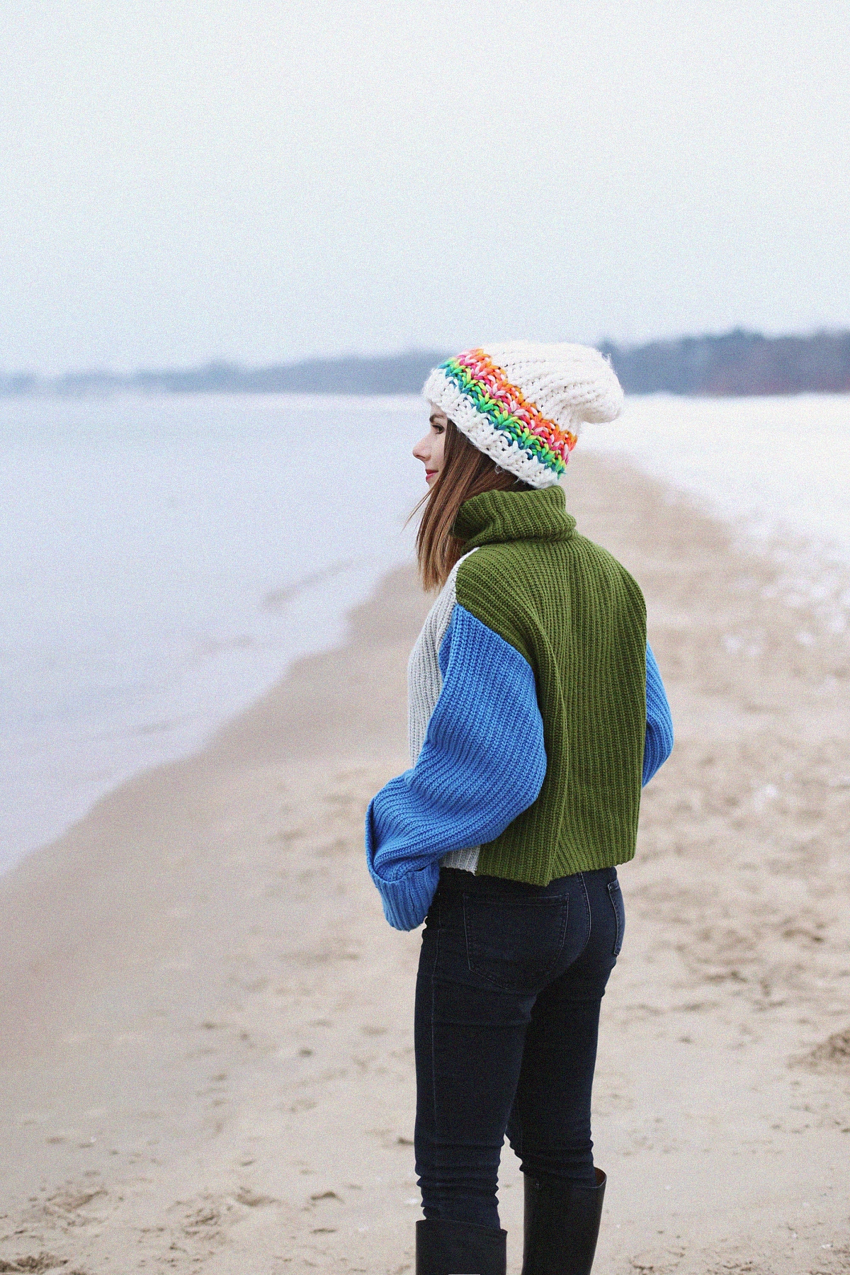 Kolorowy outfit zimowy: szeroki sweter z golfem & biała czapka o dużym splocie