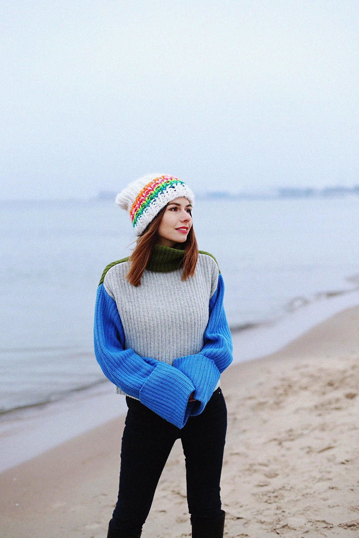 Kolorowy outfit zimowy: szeroki sweter z golfem & biała czapka o dużym splocie