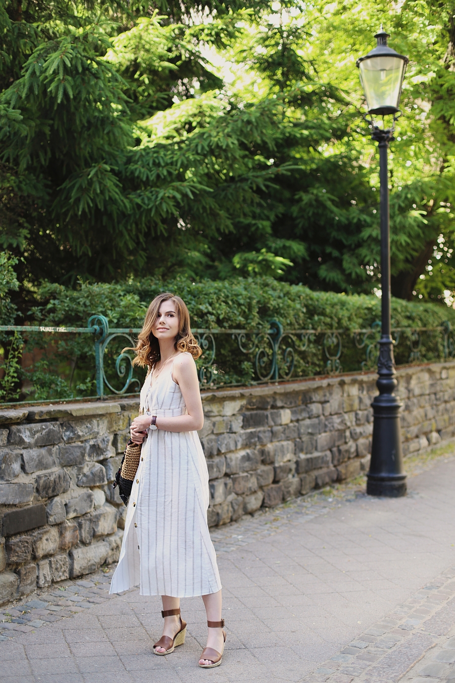 biała sukienka wiązana na biuście, pleciona torebka, espadryle